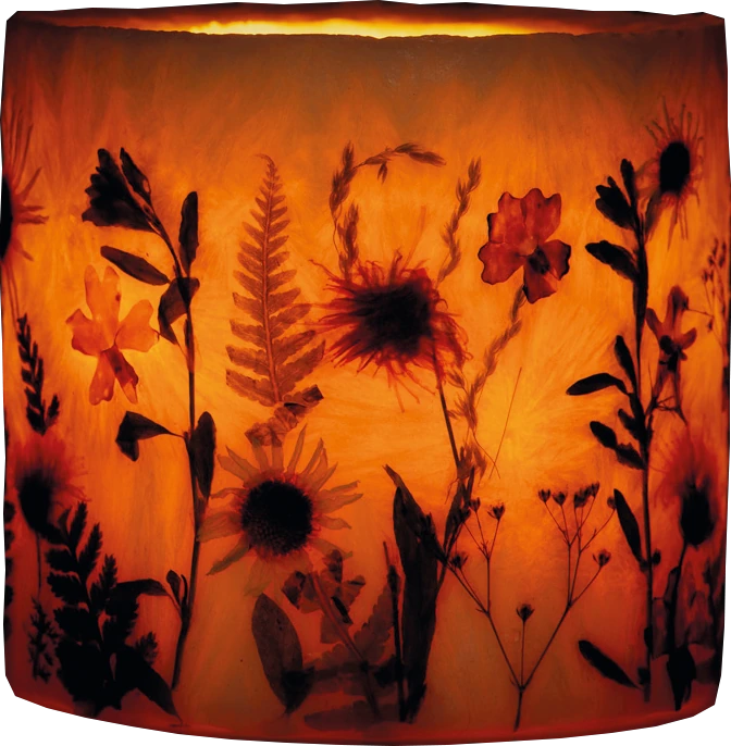 Die Wildblumenhülle leuchtet mit einem Teelicht als Windlicht